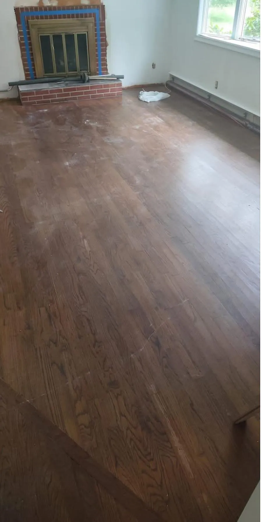 Worn dark hardwood floor before refinishing