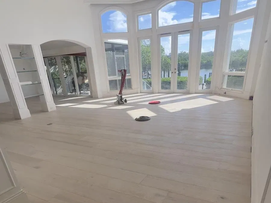 Hardwood floor sanding underway in a bright waterfront home